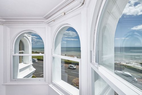 modern white uPVC sliding sash windows with arch window frame