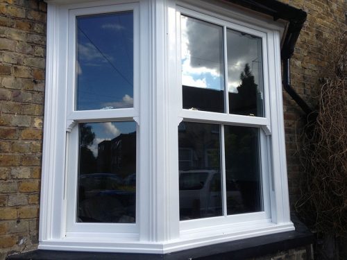 close up of white timber alternative sliding sash windows to illustrate upvc sash window prices