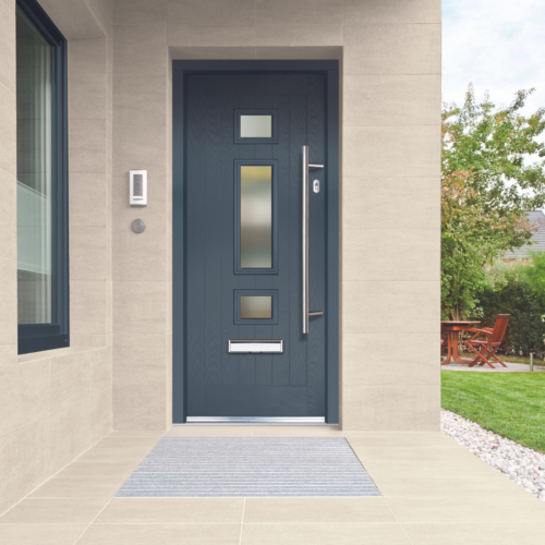 Anthracite grey contemporary composite front door with a long bar handle on a modern home