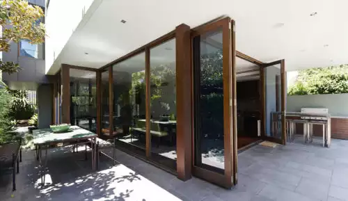 Brown aluminium folding doors open on patio area